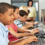 Elementary Students Working At Computers In Classroom