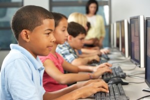 Elementary Students Working At Computers In Classroom